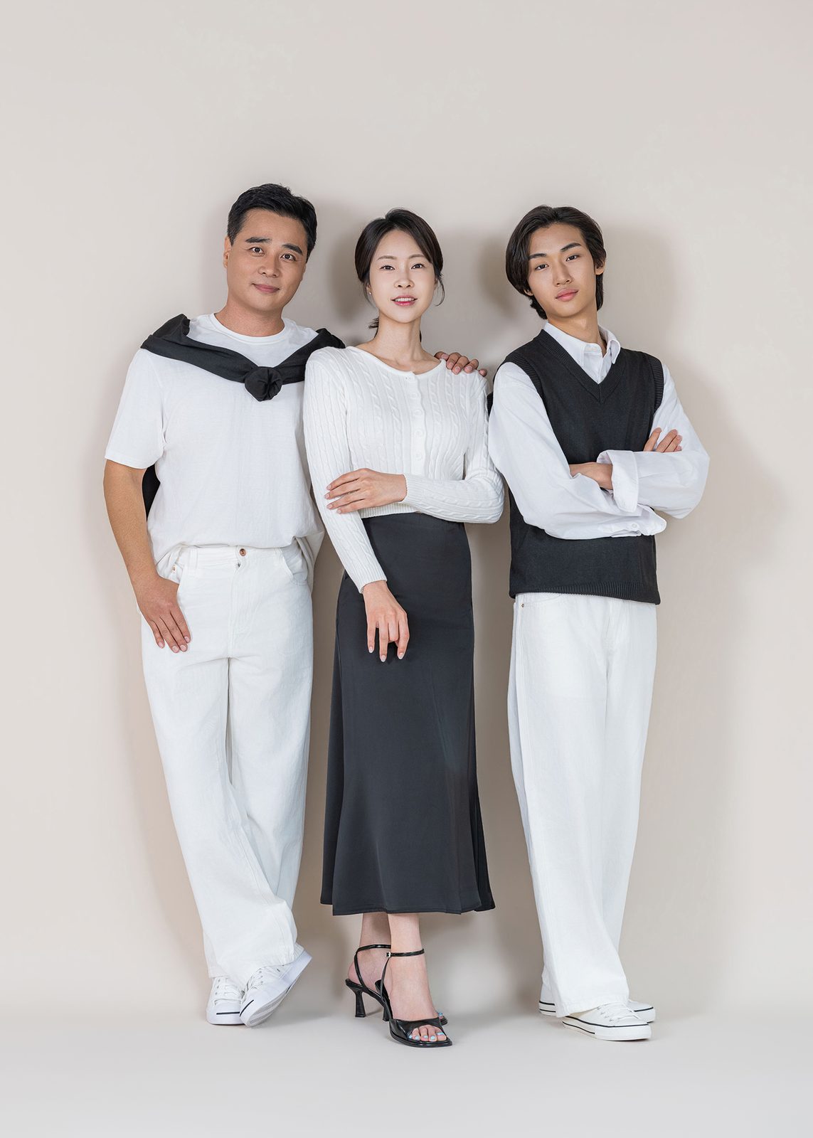 창원 블랙앤화이트 가족사진 — 세 사람이 나란히 서서 정면을 봅니다. 팔짱을 낀 아들의 표정이 사진의 중심이 됩니다