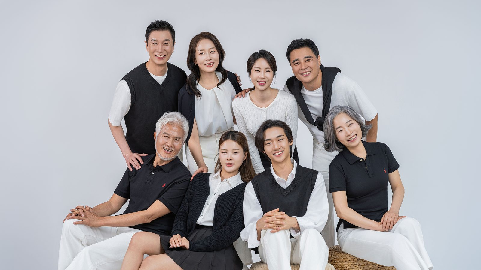 창원 블랙앤화이트 가족사진 — 여덟 식구가 어깨를 맞대고 정면을 봅니다. 흰 배경이 사진을 밝게 만듭니다