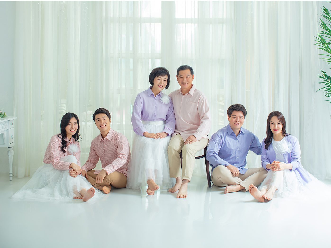 창원 캐주얼 가족사진 — 신발을 벗고 바닥에 앉은 컷. 맨발이 사진의 분위기를 한 번에 바꿉니다