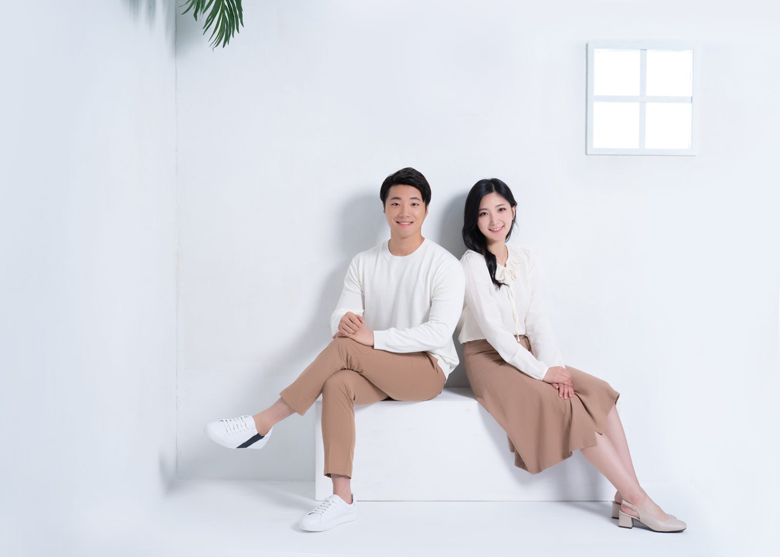 캐주얼 컨셉 촬영 스타일 예시 이미지 — 흰 벽 앞에서 나란히 앉은 가족