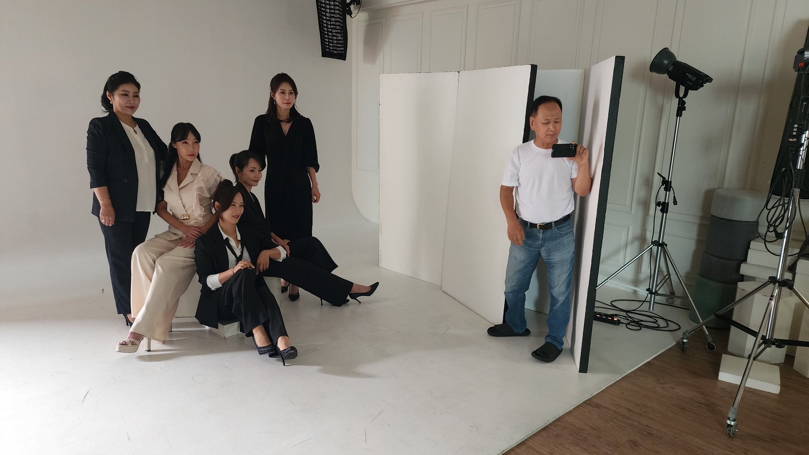 창원 우정사진 — 검은 의상을 입은 일행과 스태프가 함께 있는 촬영장