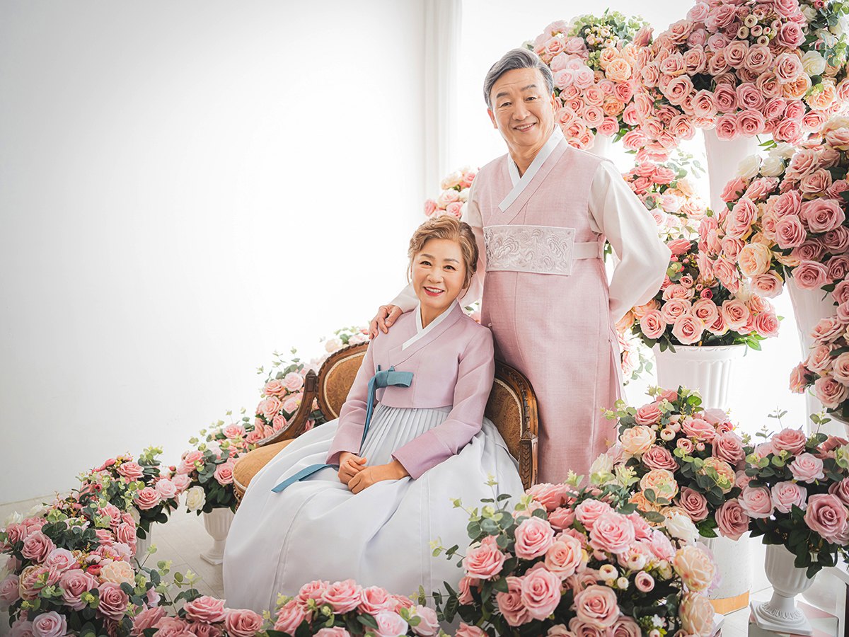 돌담과 감나무 사이, 나란히 걷는 두 사람
