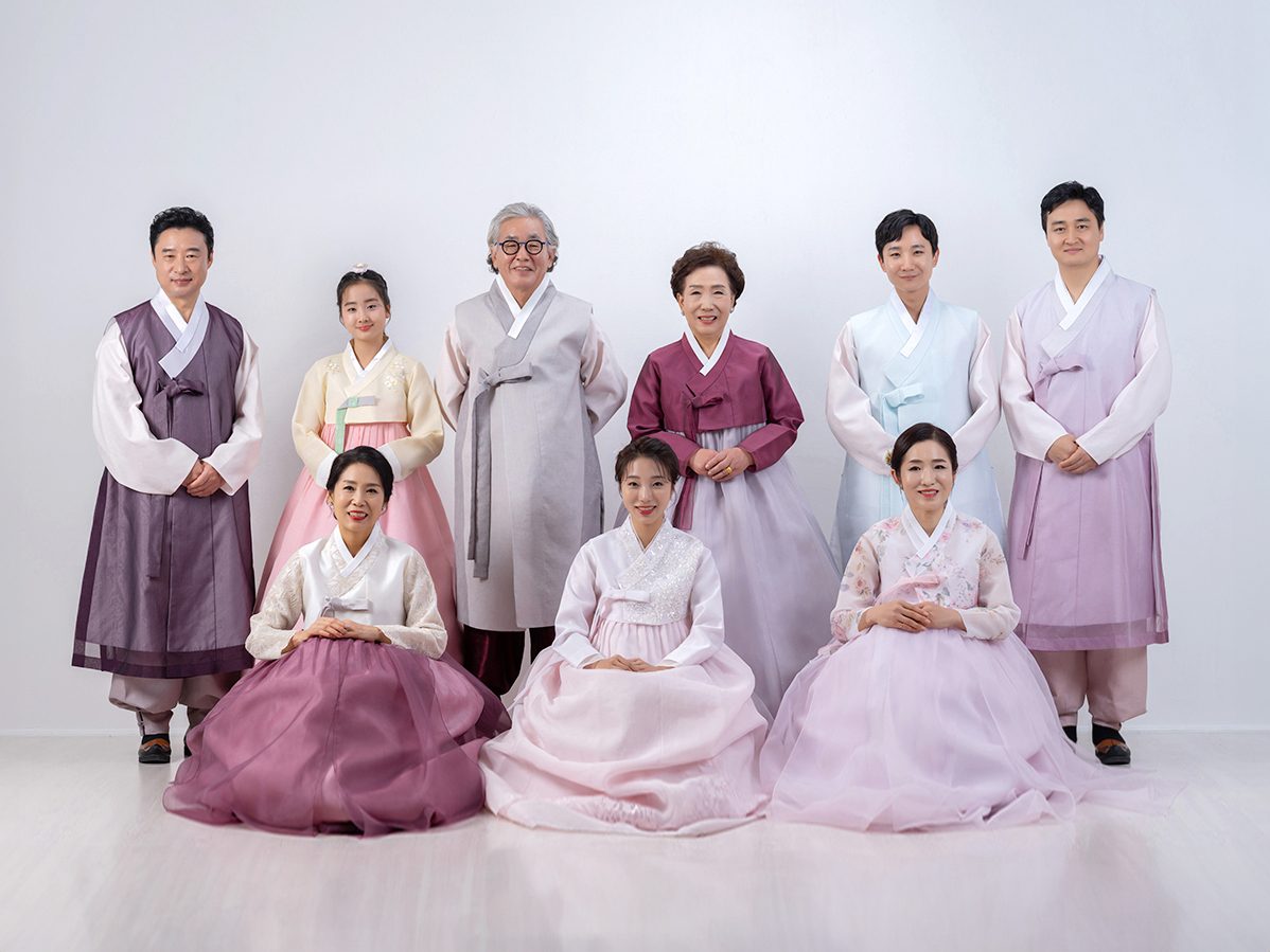 의령 한복 가족사진 — 자주색과 연보라 한복을 입은 여덟 사람. 앞줄 세 사람이 땅에 앉아 사진의 아래를 받칩니다