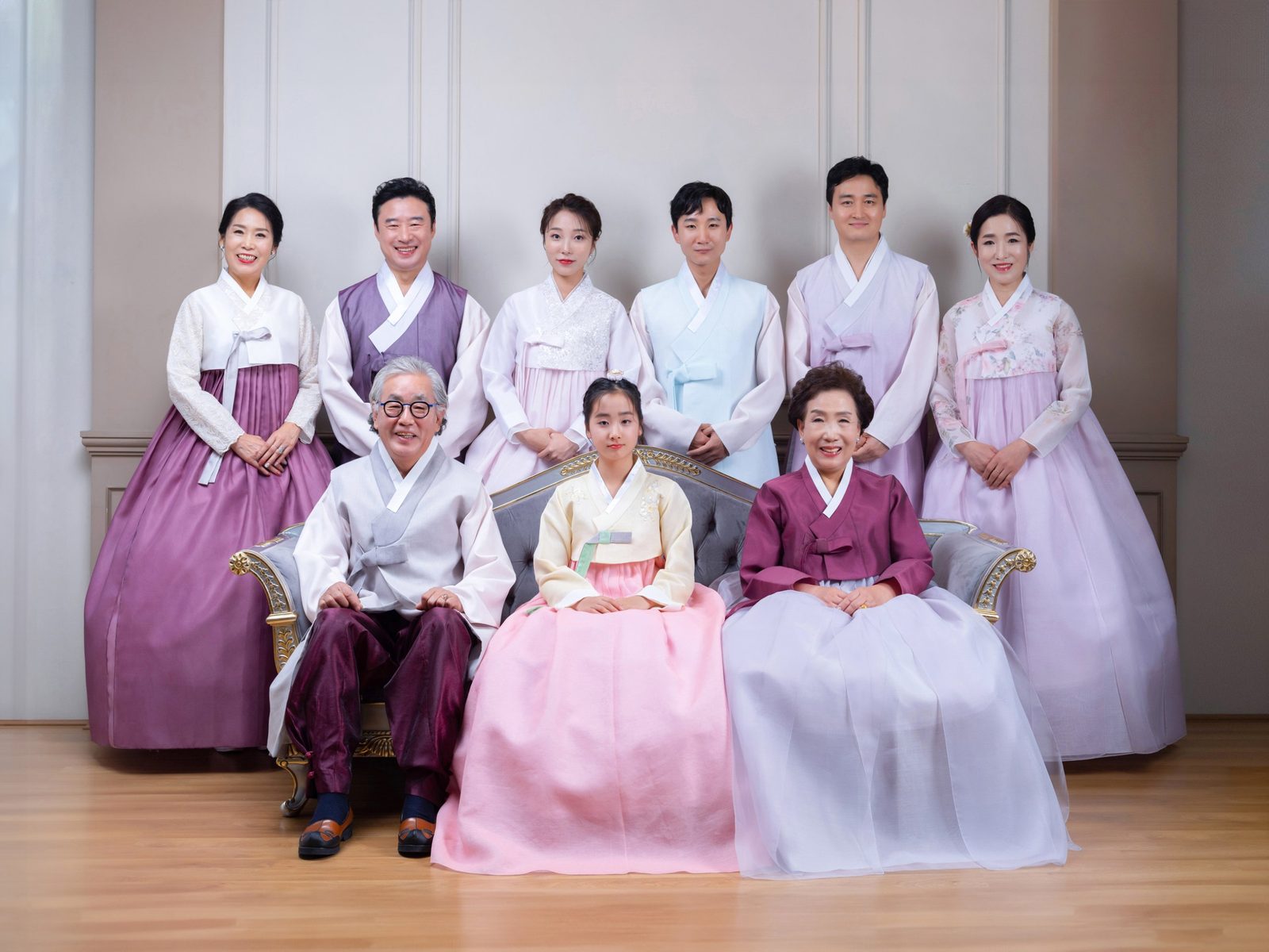 의령 한복 가족사진 — 마루에 선 아홉 사람. 할아버지와 할머니가 가운데 앉고 세대가 층층이 둘러섰습니다