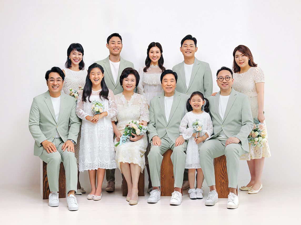 창원 세미웨딩 가족사진 — 민트빛 수트와 흰 드레스로 맞춘 열한 사람. 세 줄로 나누어 서니 얼굴이 다 보입니다